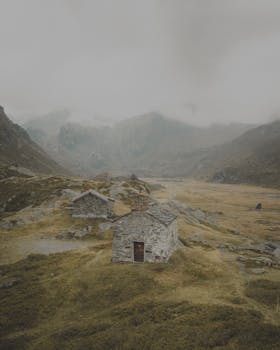 Moody landscape of stone houses in a misty French alpine valley.