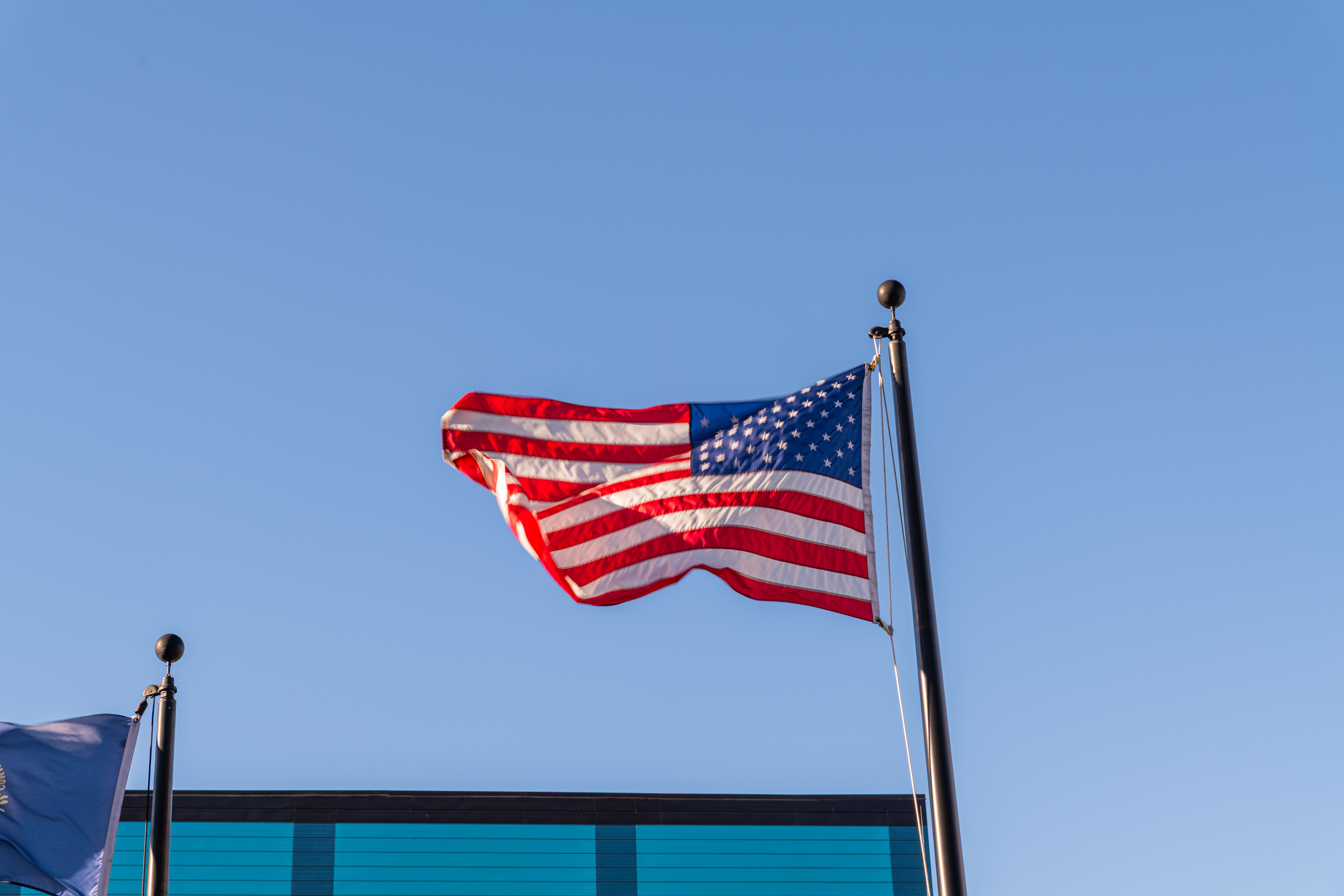 American Flag Waving Against Clear Blue Sky · Free Stock Photo
