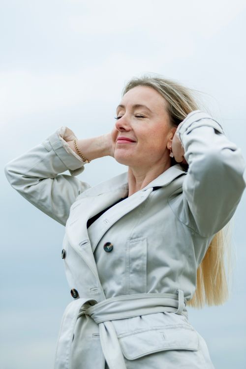 Free Woman enjoying a serene outdoor moment with closed eyes and relaxed posture. Stock Photo