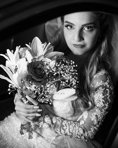 Grayscale Photography of Woman Carrying Flower Bouquet