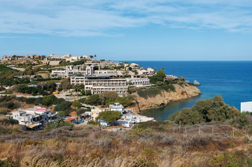 Free Explore the stunning coastline of Crete, Greece, showcasing a vibrant resort village and crystal-clear Mediterranean waters. Stock Photo