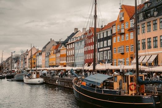 Vibrant Nyhavn canal view with historic buildings and boats in Copenhagen, Denmark.