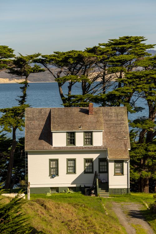 Free Charming white house by sea with scenic ocean view. Ideal nature and travel setting. Stock Photo