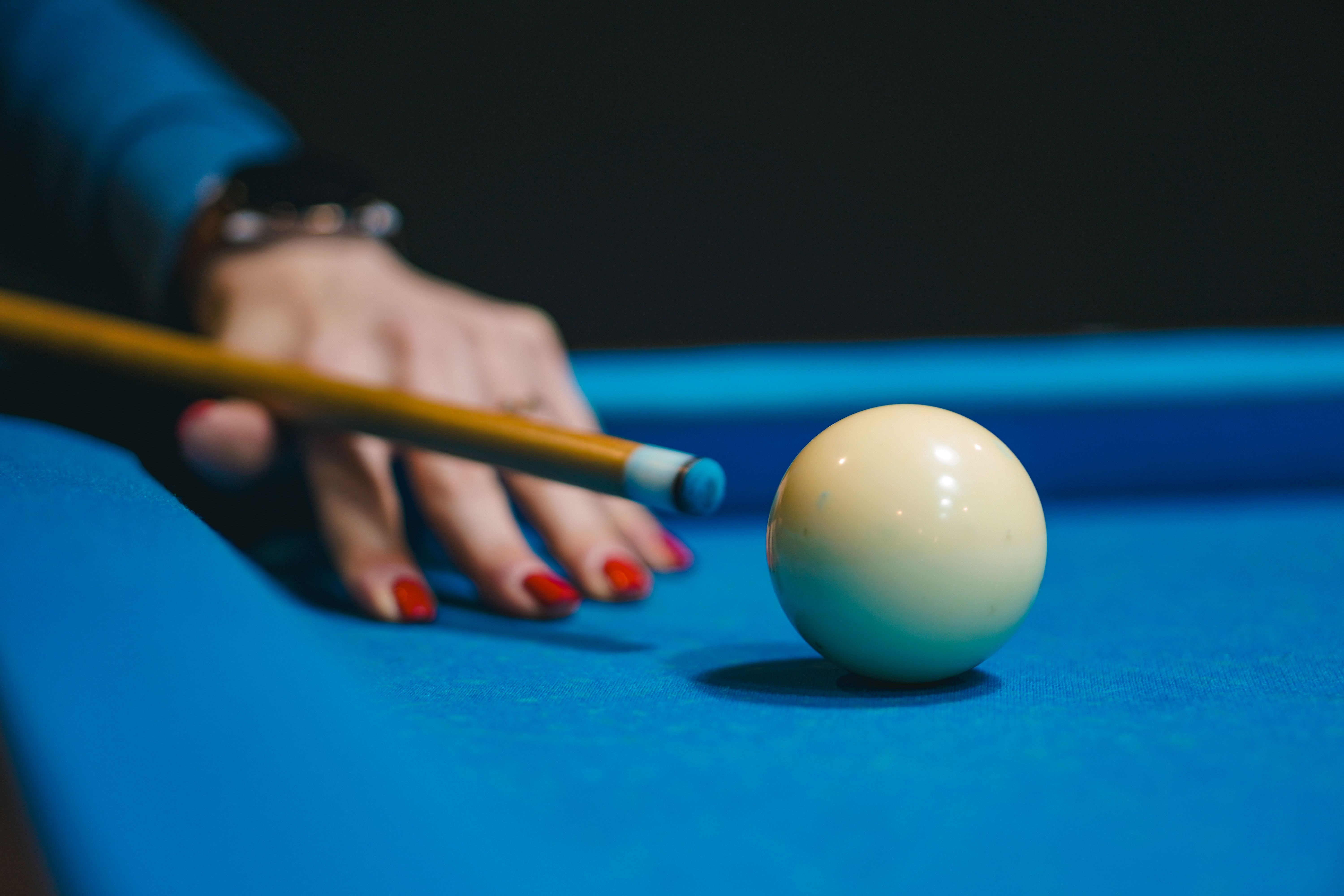 A focused billiard shot on a blue table in a Kyiv pool hall captures precision and style.