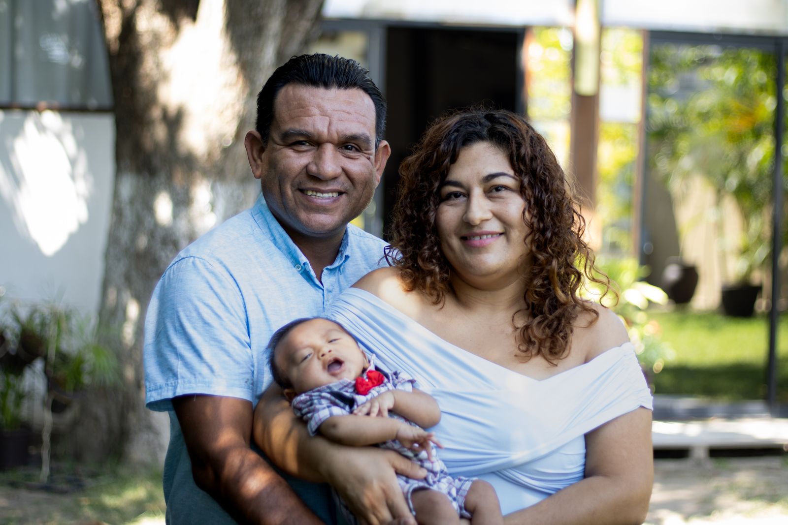 Parents smiling with their baby outdoors