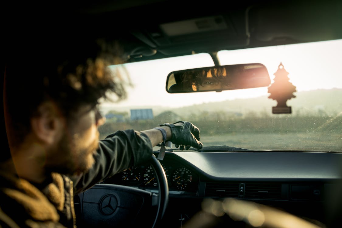 Man Inside A Car With Reflection On Rear View Mirror