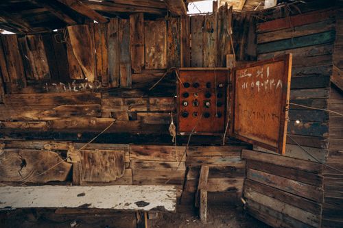 Free A weathered electrical panel inside a vintage wooden shed showcasing rustic textures. Stock Photo