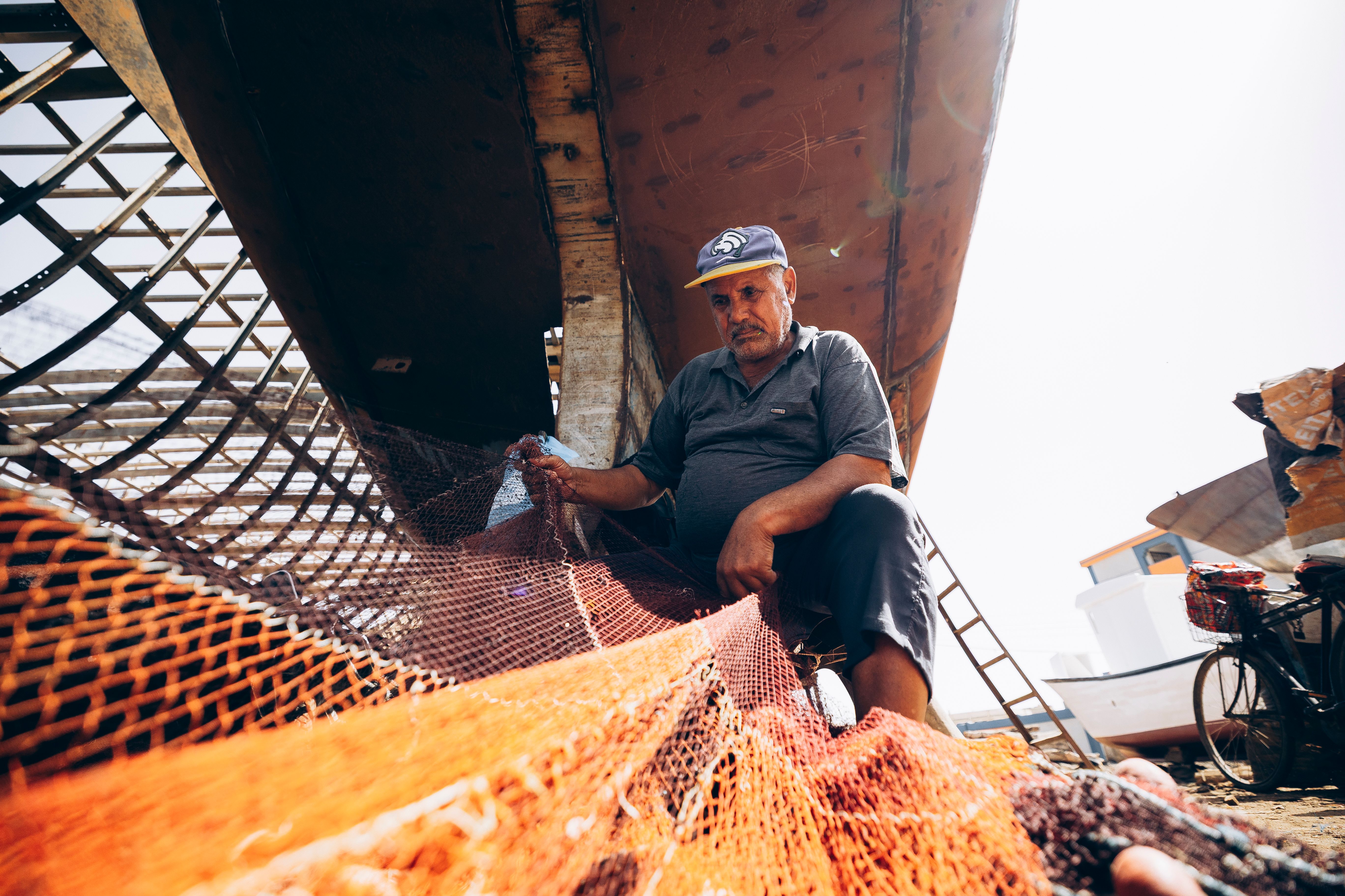 Fisherman Repairing Net at Damietta Dock · Free Stock Photo