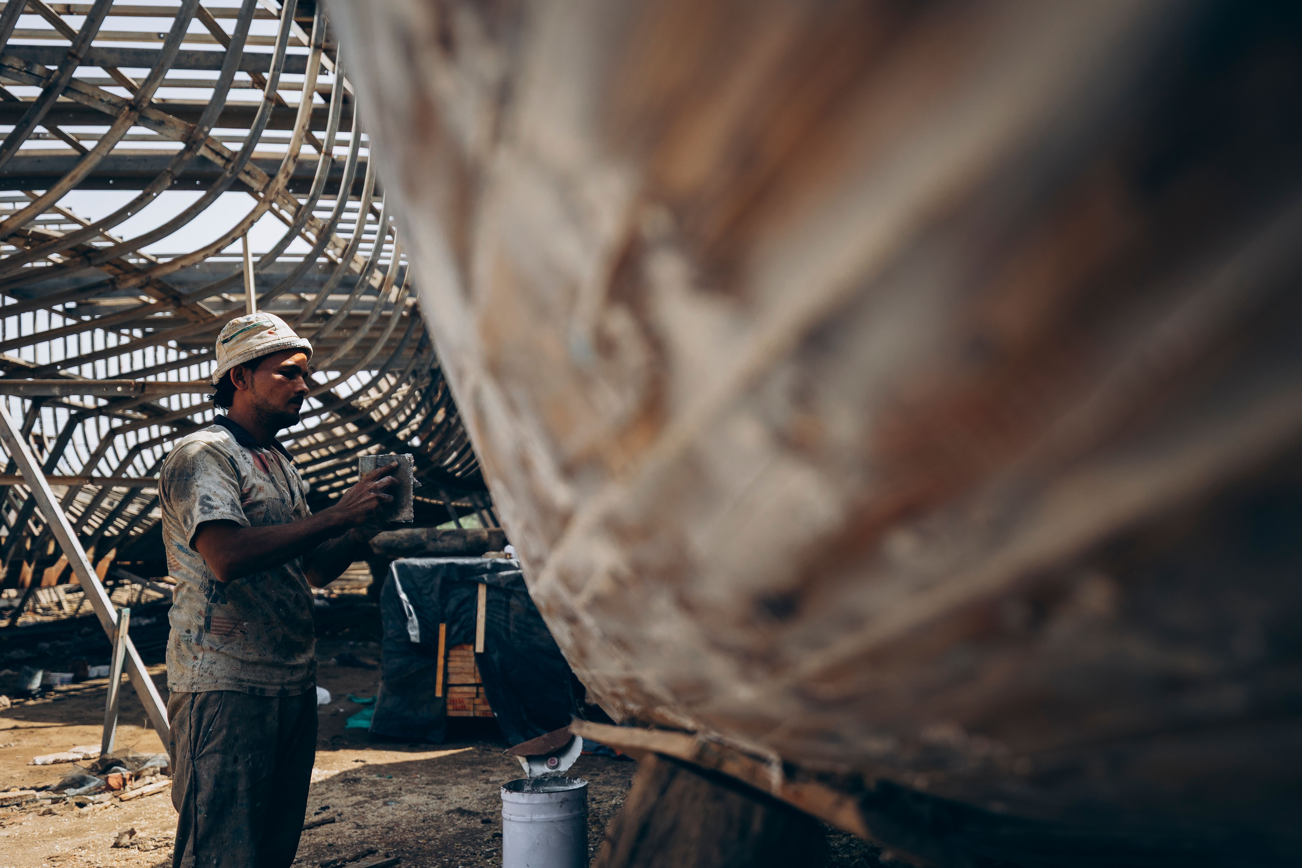 Shipbuilder crafting vessel in Damietta, Egypt. Captures traditional boat-making with a focus on craftsmanship.