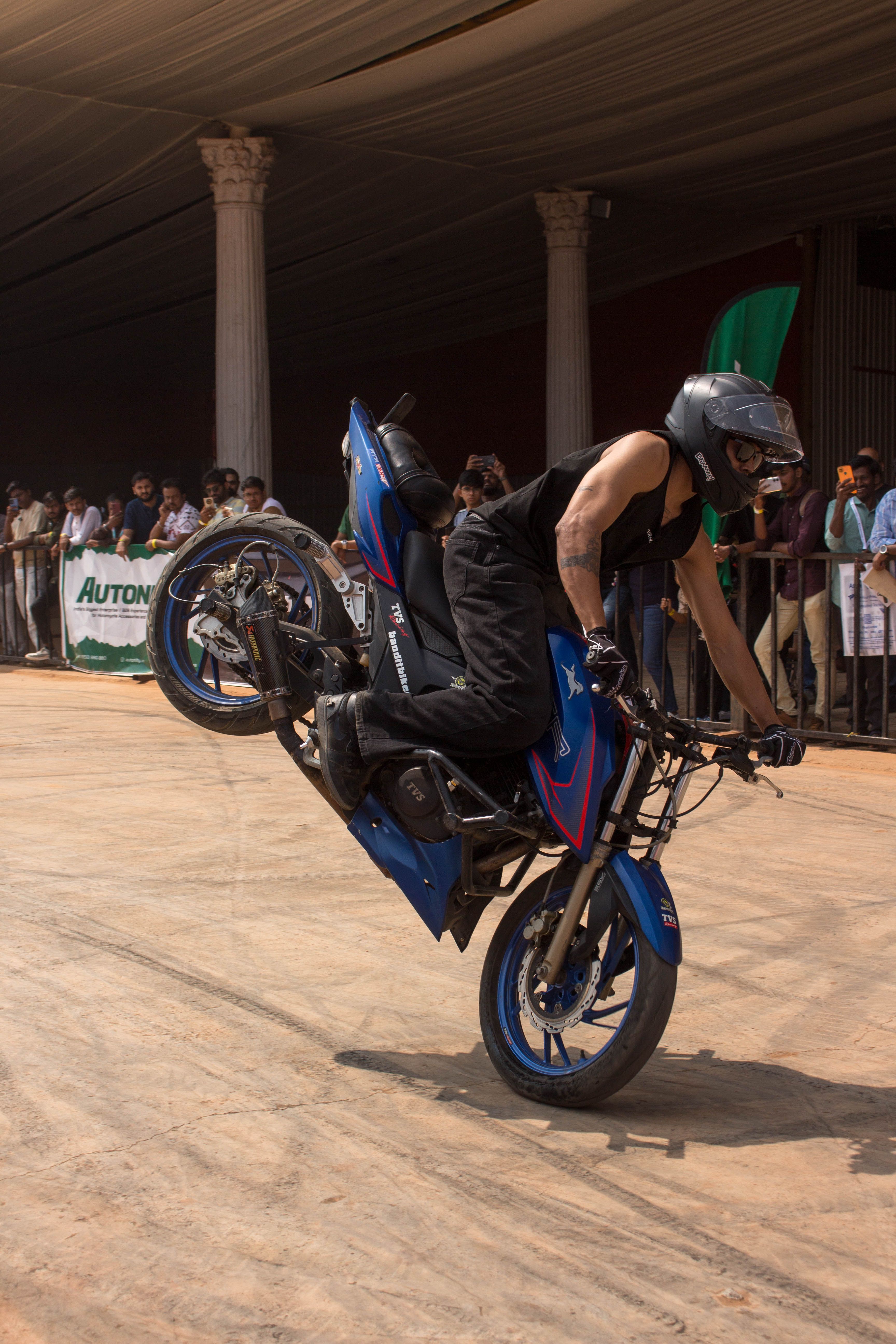 Dynamic Motorcycle Stunt Rider Performing Wheelie · Free Stock Photo