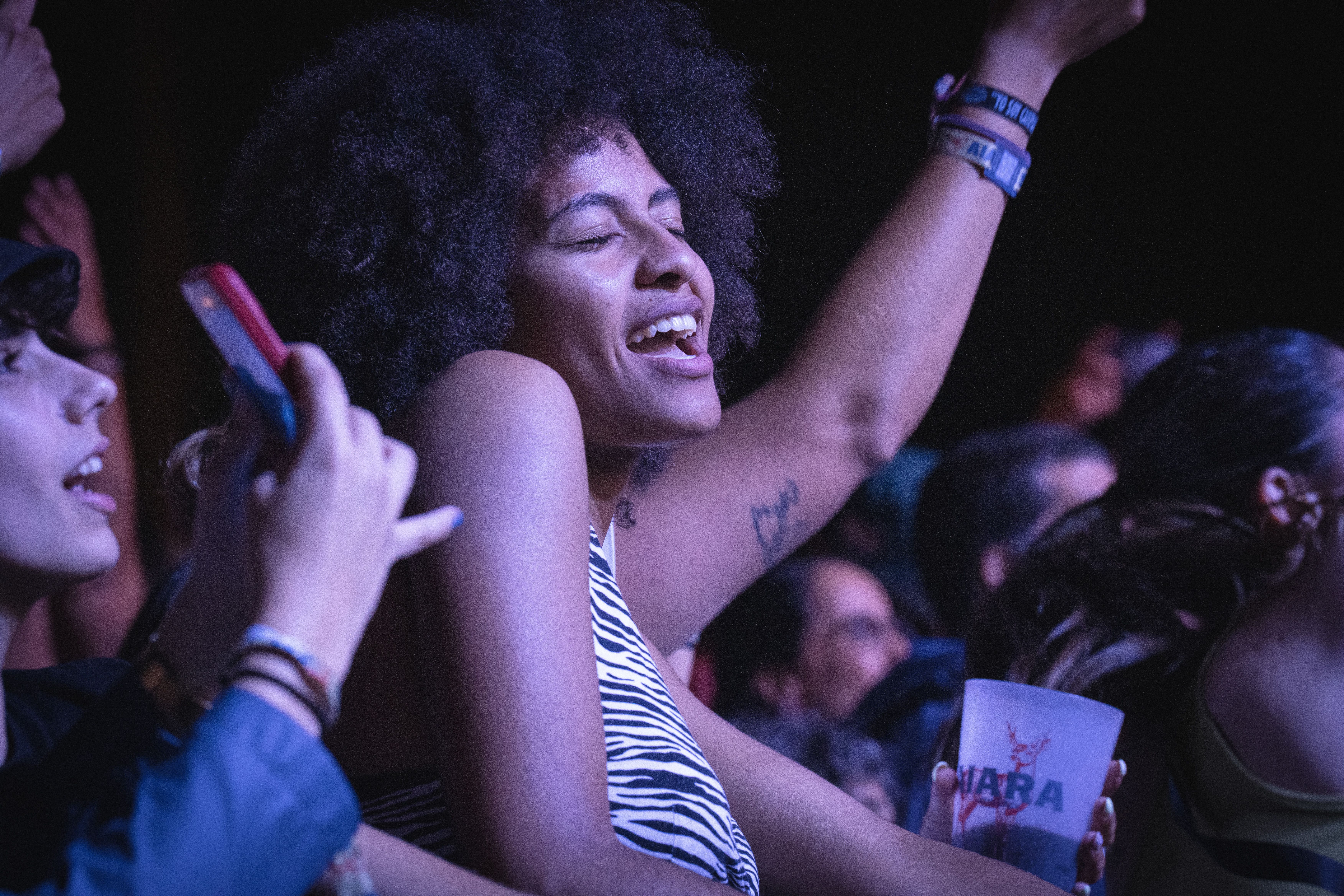 Cheerful woman enjoying a live concert, capturing the vibrant atmosphere.