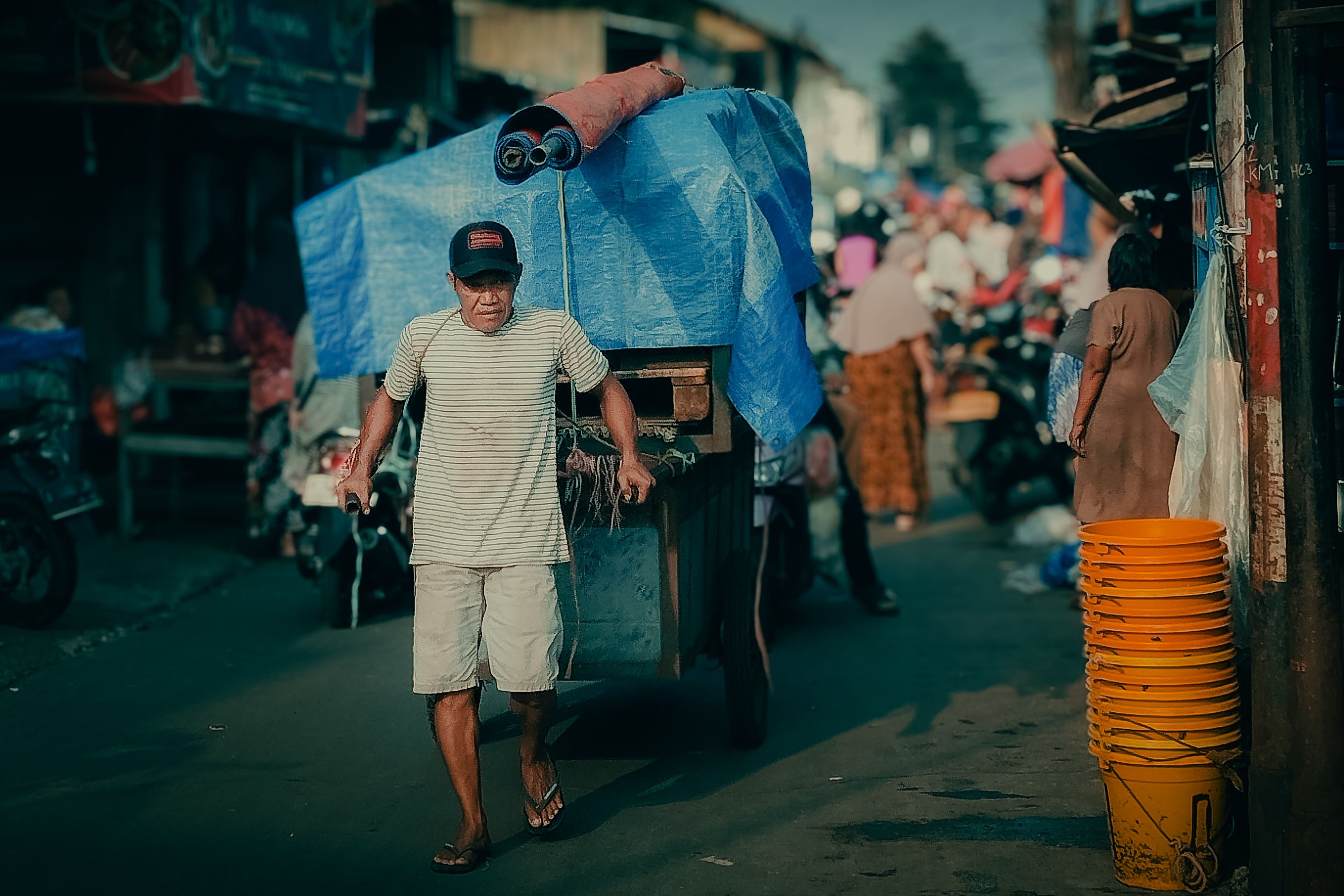 Man Pulling Cart in Busy Outdoor Market