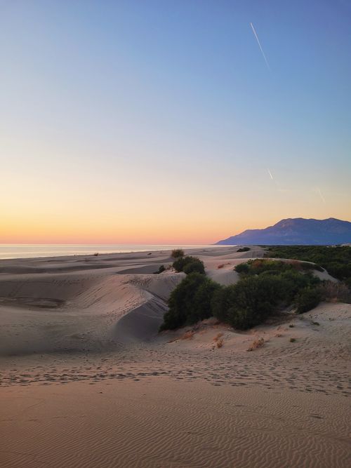 Free Captivating view of a tranquil desert scene at sunset with distant mountains and clear sky. Stock Photo