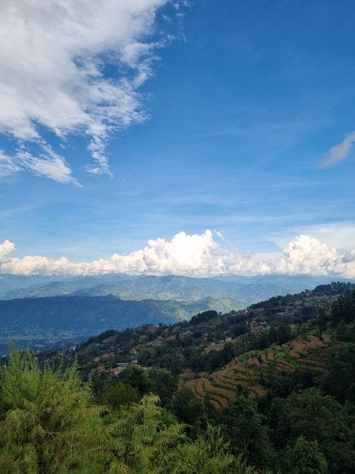 Free Beautiful view of Nepal's green hills and clouds under a blue sky. Stock Photo