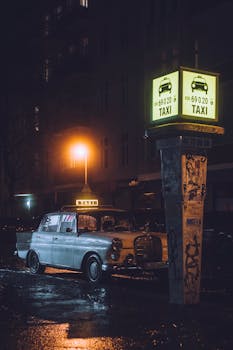 Moody night shot of a vintage taxi in Berlin under glowing streetlights with a retro vibe.