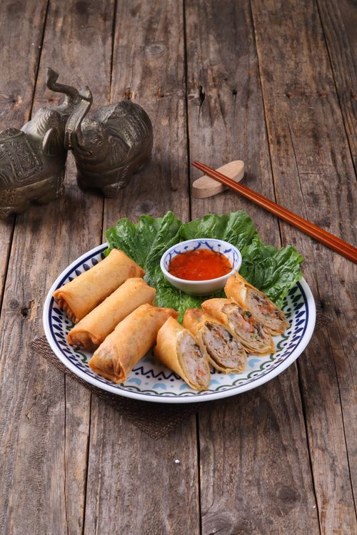 Free Appetizing spring rolls served with spicy sauce on a rustic table. Stock Photo