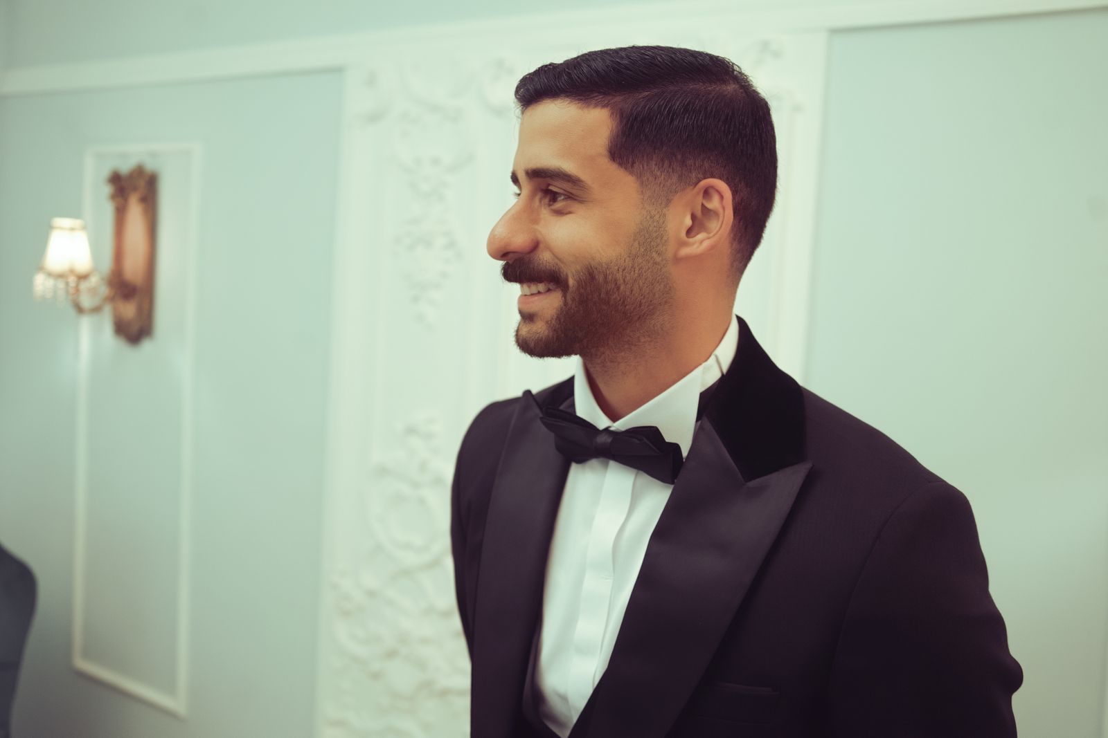 A well-dressed groomsman smiling at a wedding