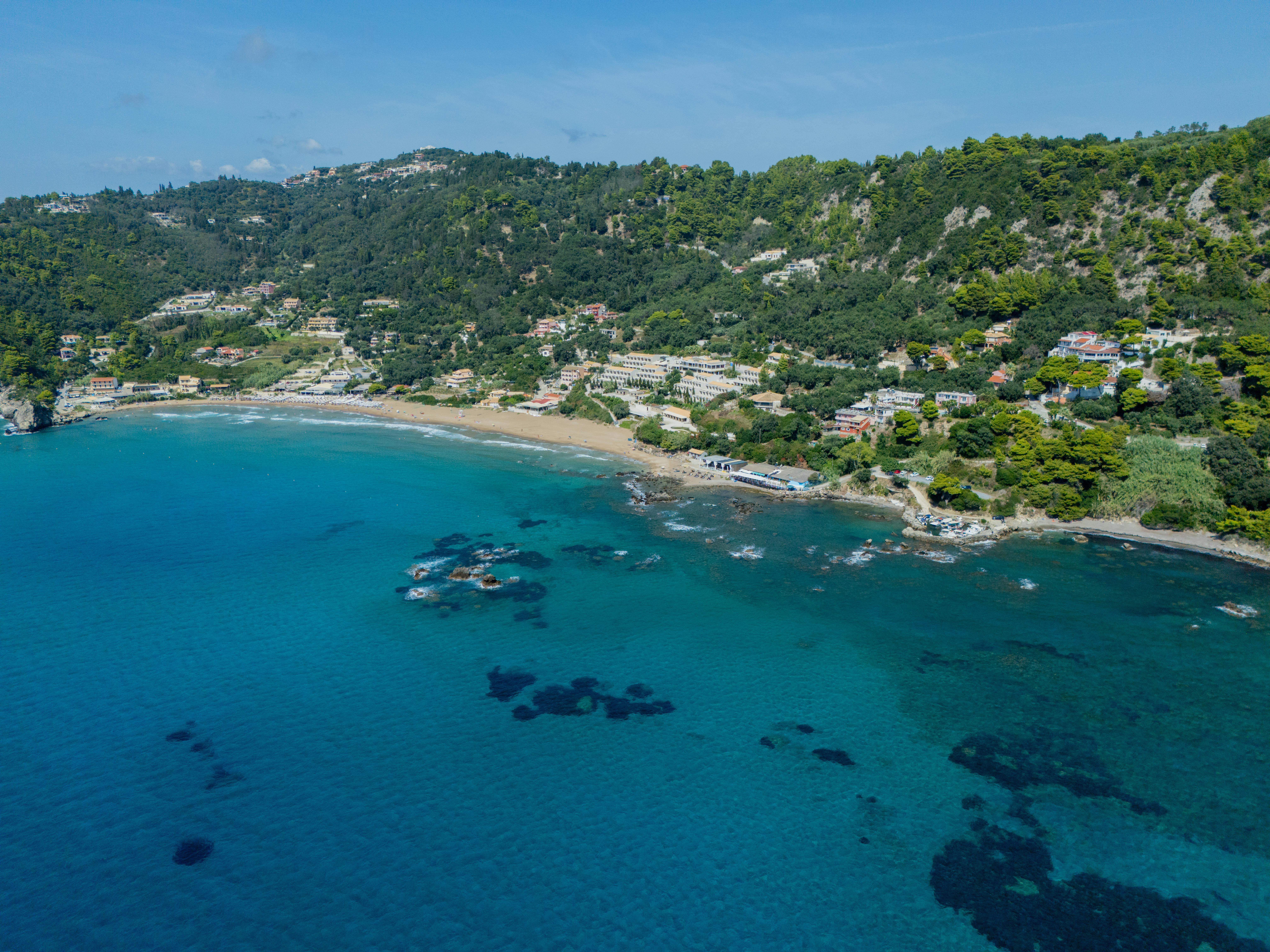 De franc Impressionant vista aèria de la platja de Glyfada a l'illa de Corfú, Grècia, amb aigües blaves cristal·lines i una vegetació exuberant. Foto d'estoc