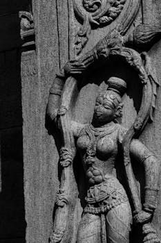 Detailed black and white stone carving of a deity at Melukote Temple, depicting rich heritage craftsmanship.