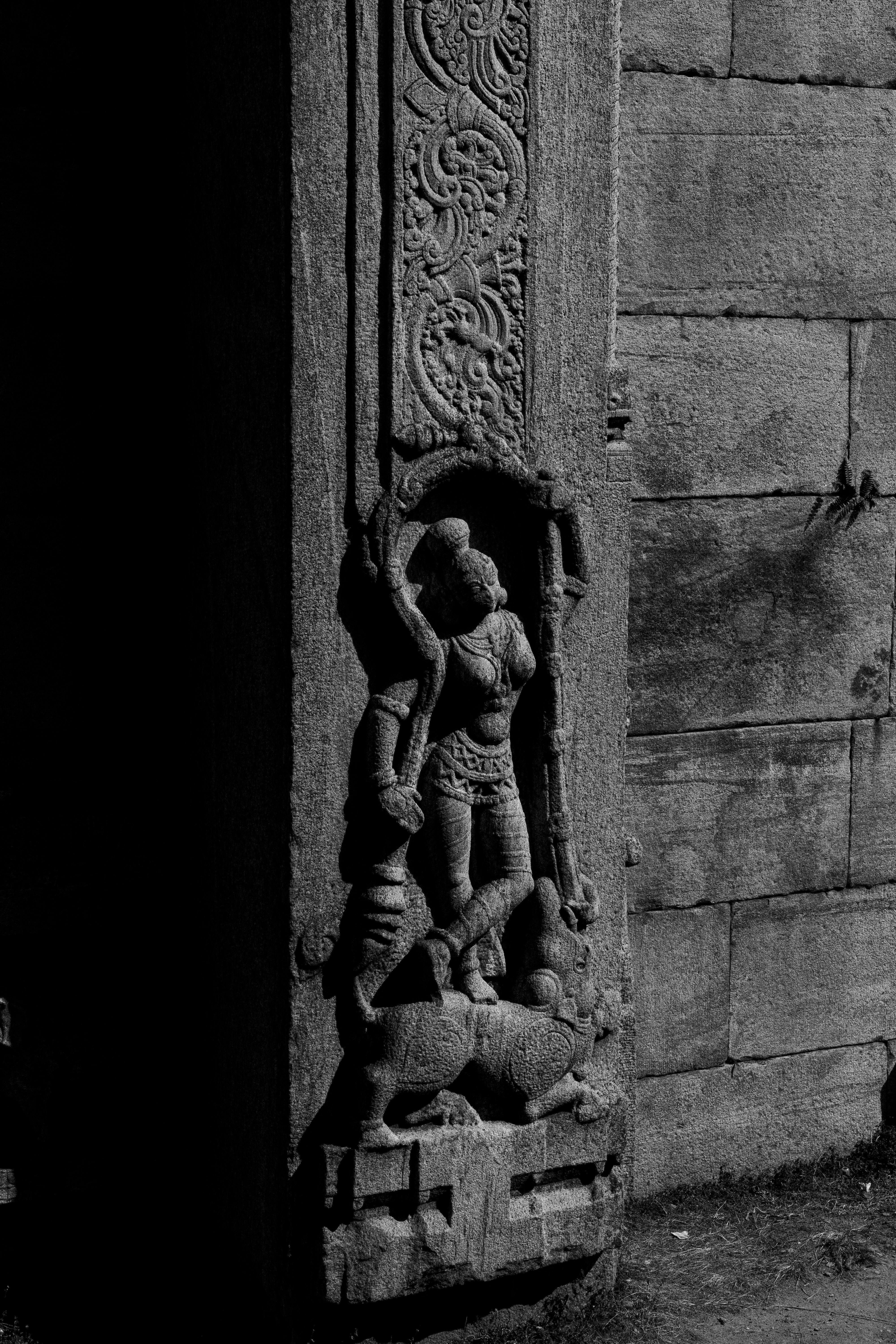 Detailed stone carving depicting Hindu deities at Melukote Temple in Karnataka, India.