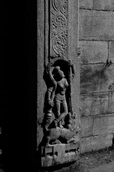Detailed stone carving depicting Hindu deities at Melukote Temple in Karnataka, India.