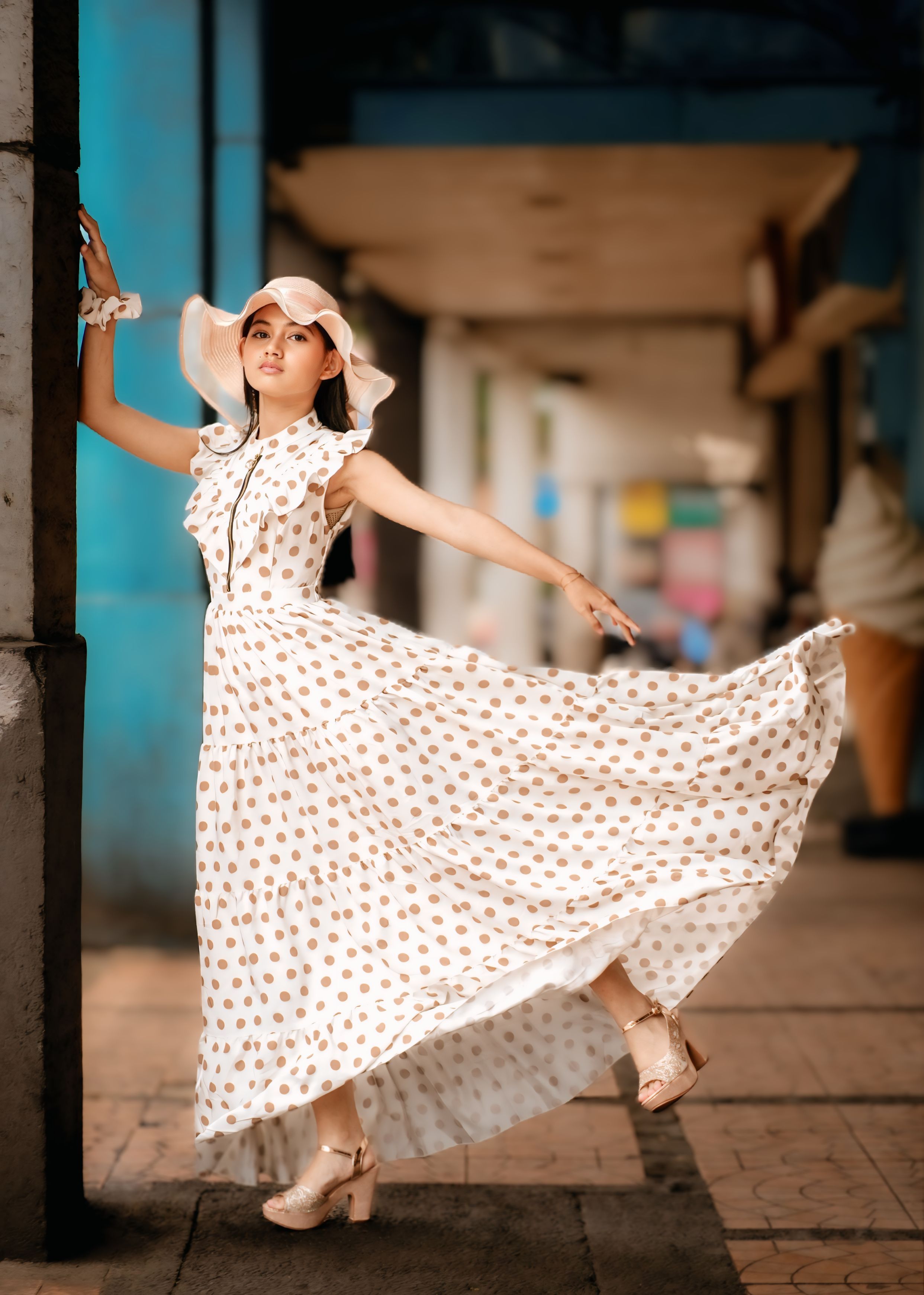 Stylish woman in polka dot dress poses gracefully outdoors in Jawa Barat.
