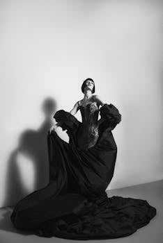 Artistic portrait of a model in a dramatic black dress in studio lighting.