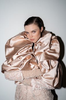 A model in a luxurious satin wrap poses elegantly against a plain background.