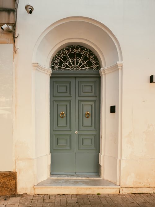 Free Charming vintage doorway with pale green wooden door and traditional arch design, perfect for architecture themes. Stock Photo