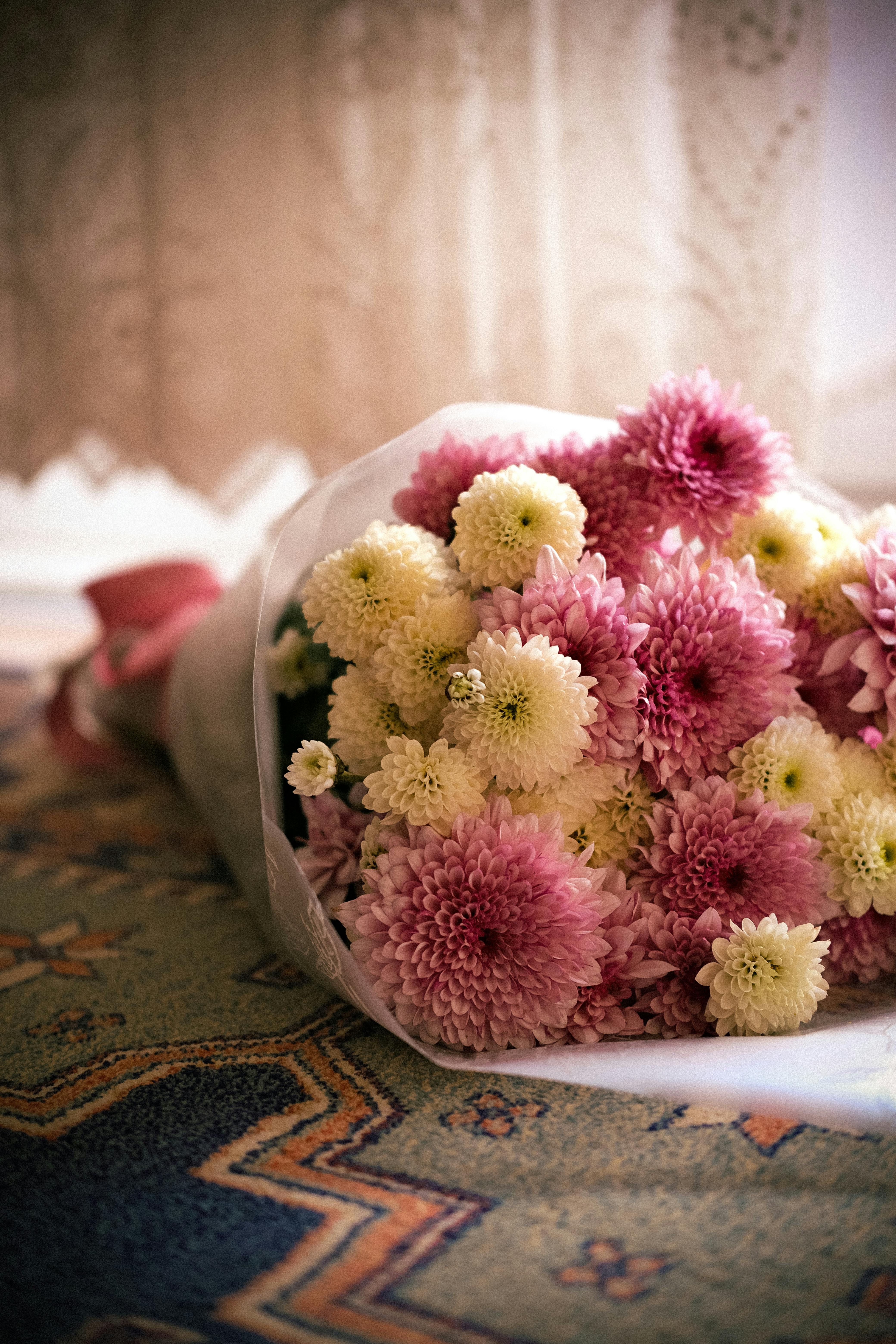 Gratis Un delicato bouquet di crisantemi rosa e bianchi, perfetto per le feste o per decorare una stanza in primavera. Foto a disposizione