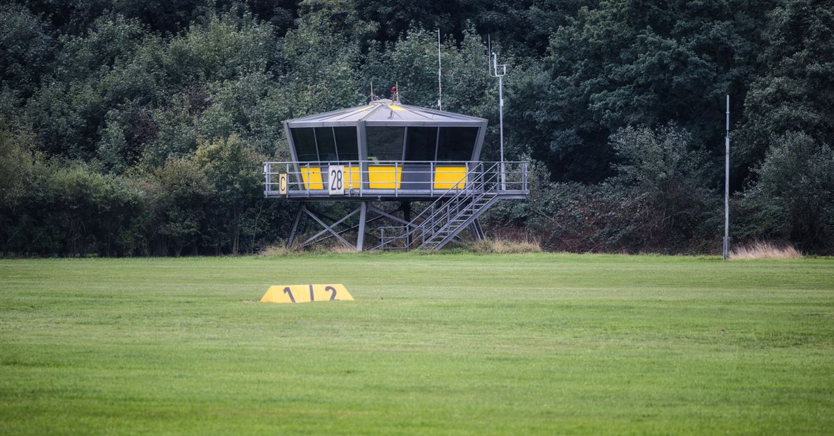 A rural airfield control tower surrounded by lush greenery, perfect for small aircraft coordination.