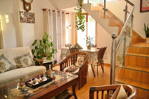 Free Beautiful living room interior with wooden furniture and lush indoor plants, creating a warm and inviting atmosphere. Stock Photo