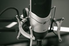 Close-up of a sleek microphone setup in a modern recording studio, capturing sound with precision.