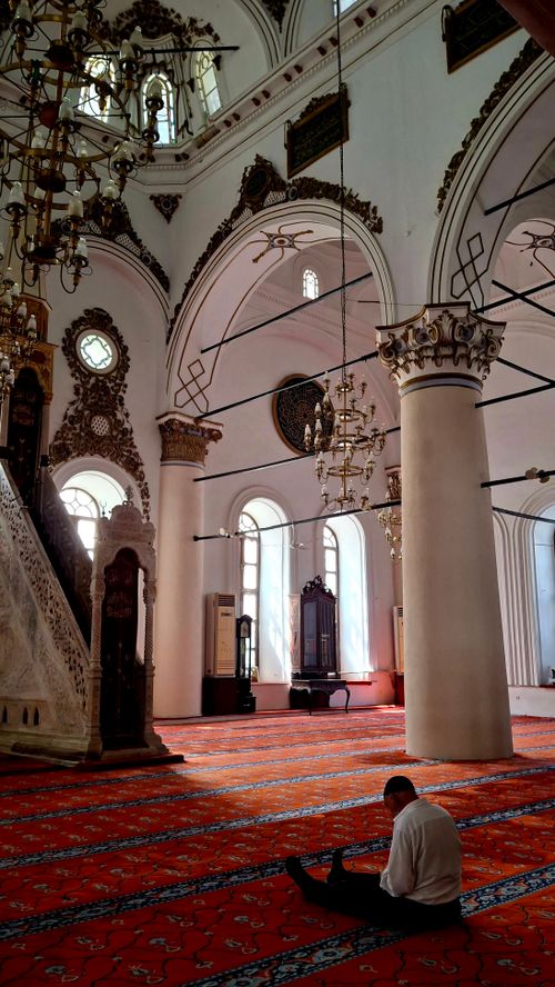 Free Ornate mosque interior with a man praying, showcasing intricate architecture and peaceful ambiance. Stock Photo