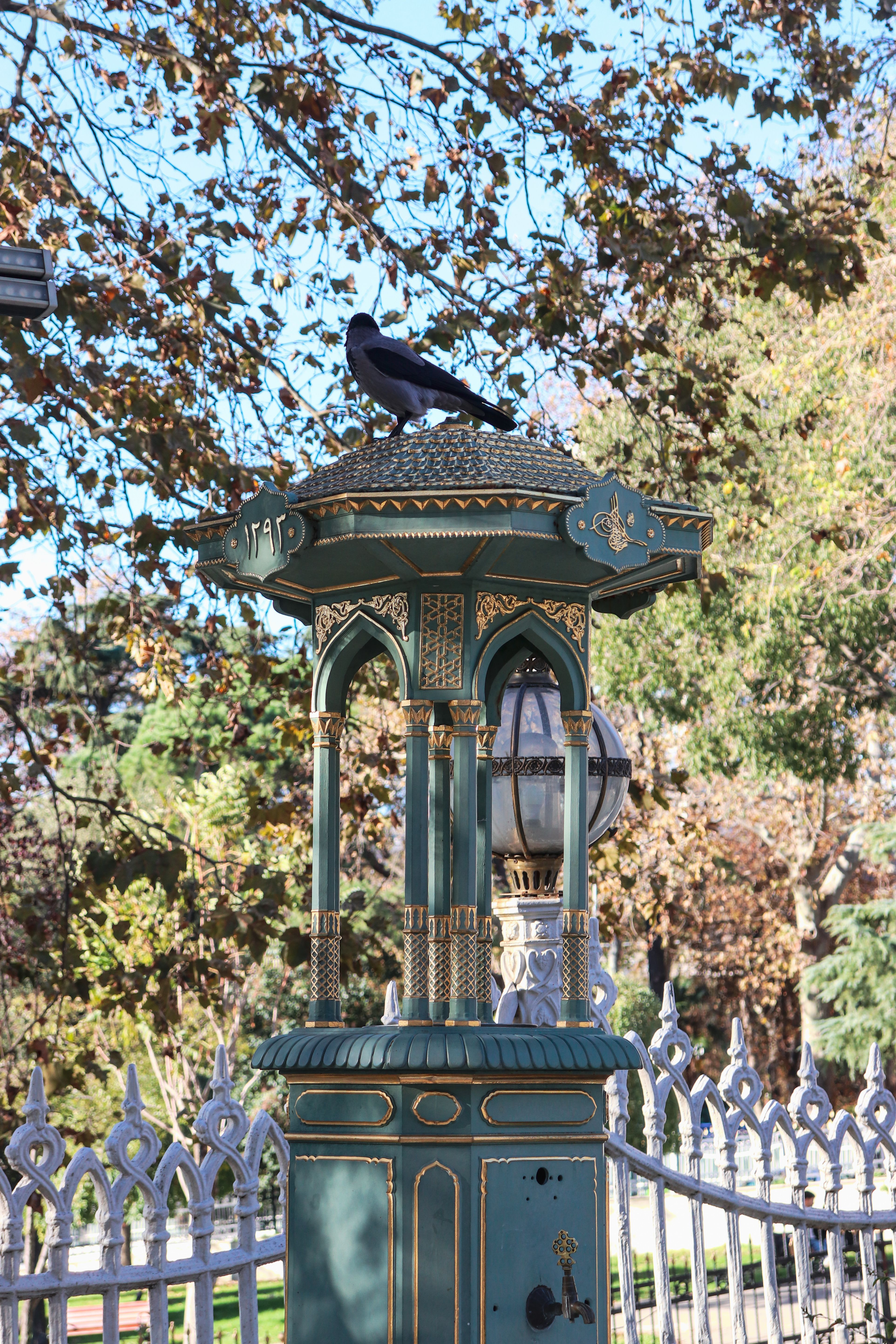 Majestic Lamp Post with Crow in Autumn Park · Free Stock Photo