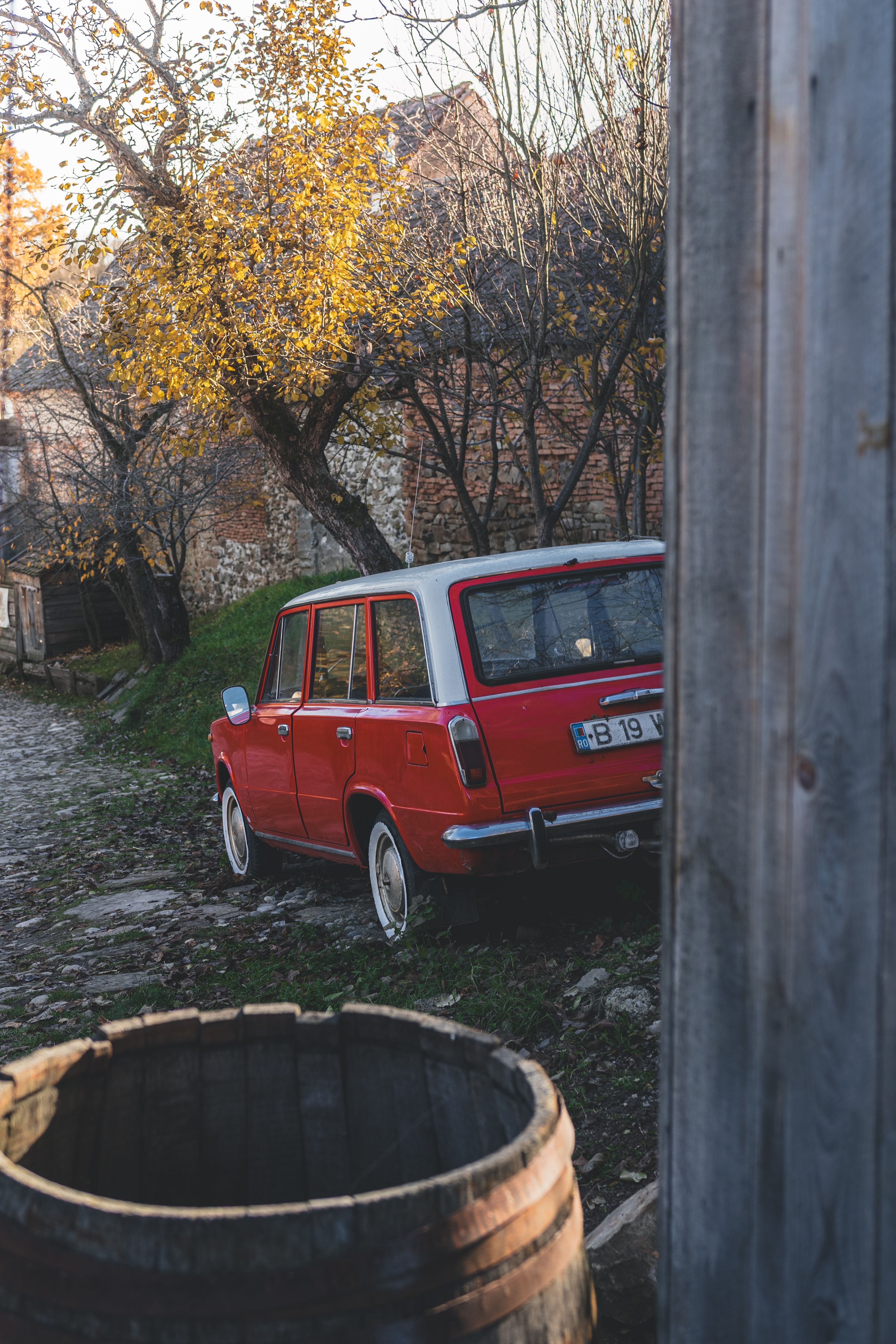 Vintage Red Car in a Rustic Countryside Setting · Free Stock Photo