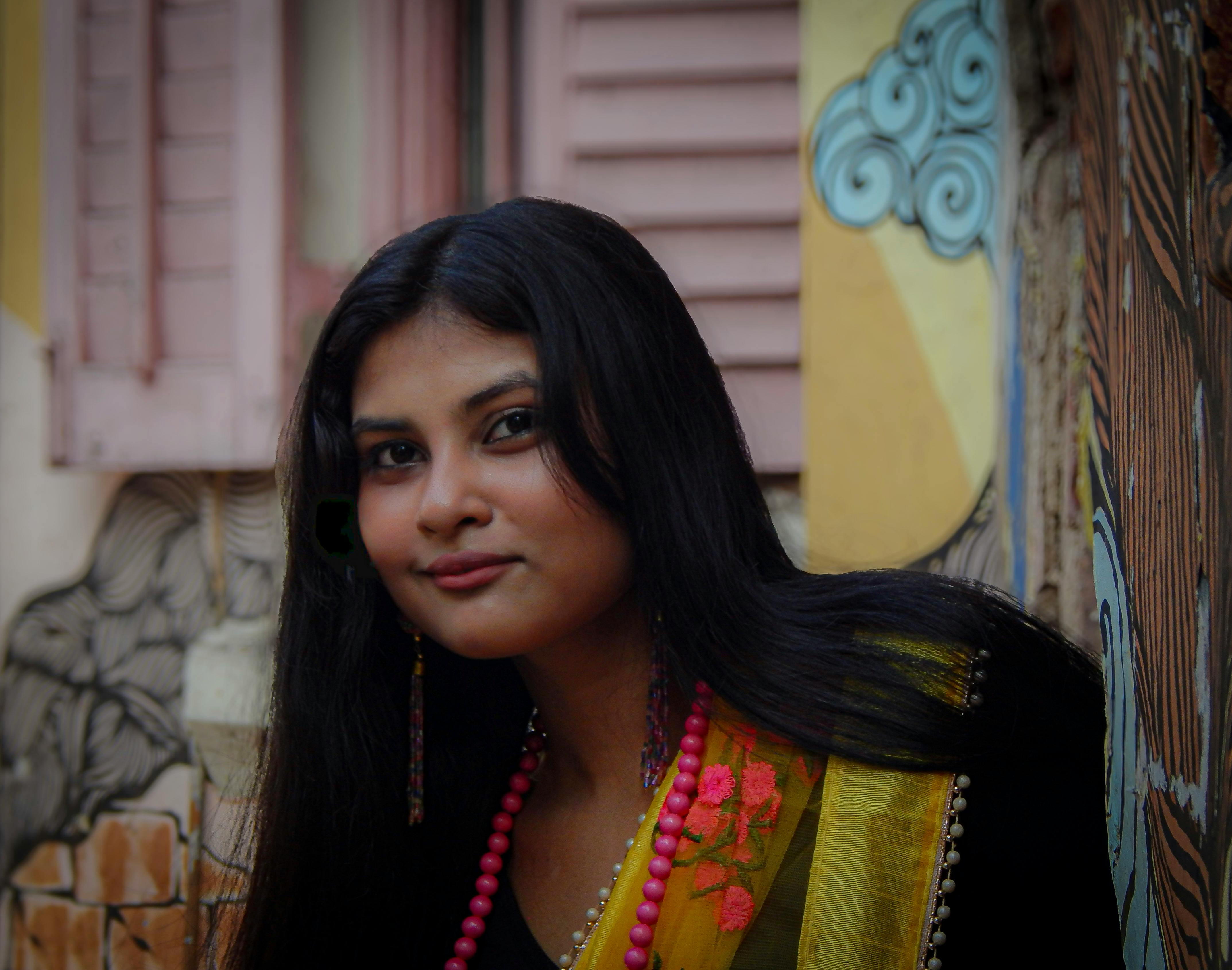 Young woman in a colorful saree with traditional accessories in Kolkata, India.