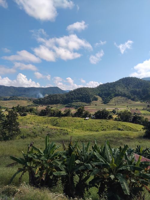 Free Beautiful rural landscape with lush greenery, hills, and vibrant sky. Stock Photo