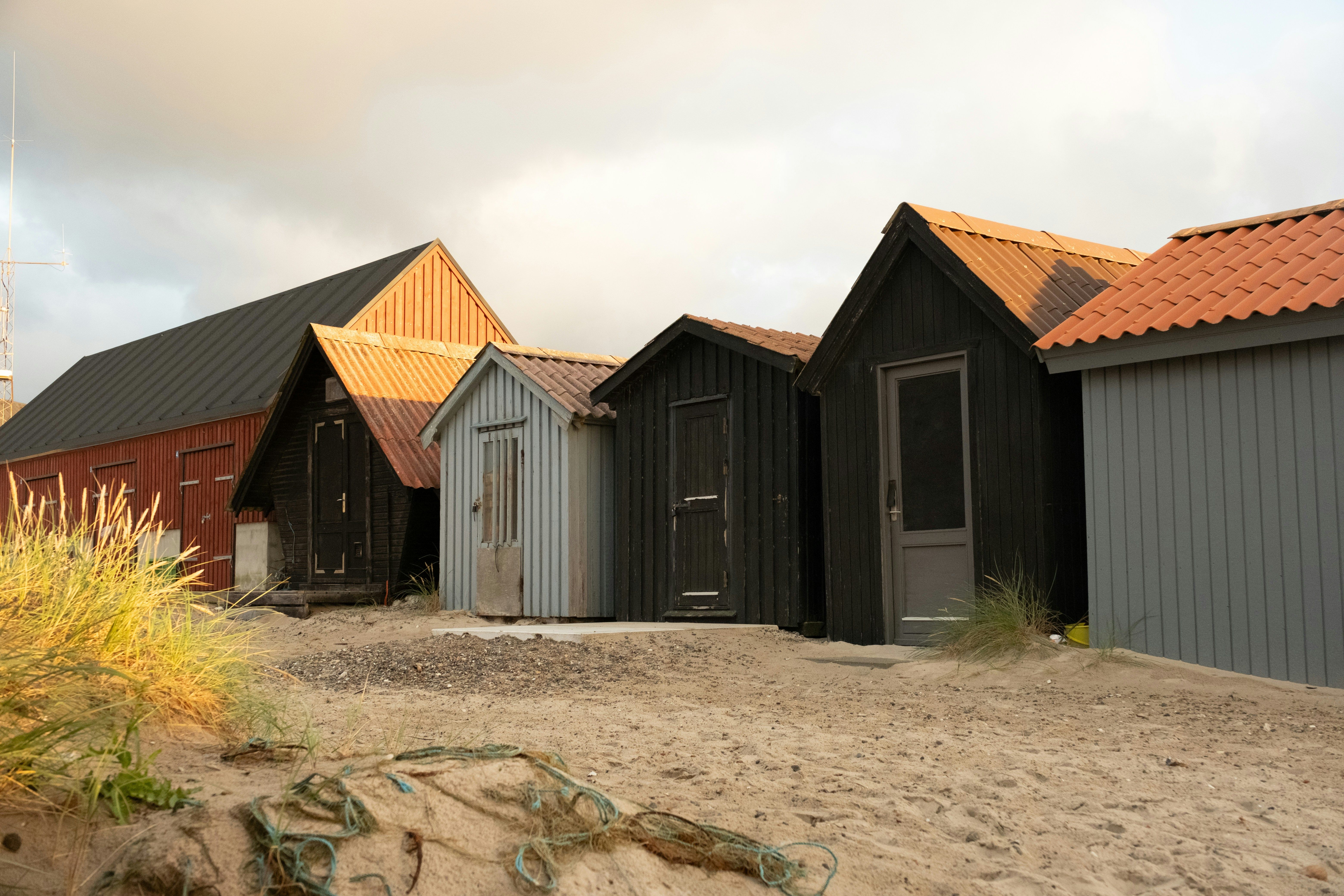 A serene view of traditional coastal huts in Thisted, Denmark, captured during sunset highlighting their rustic charm.