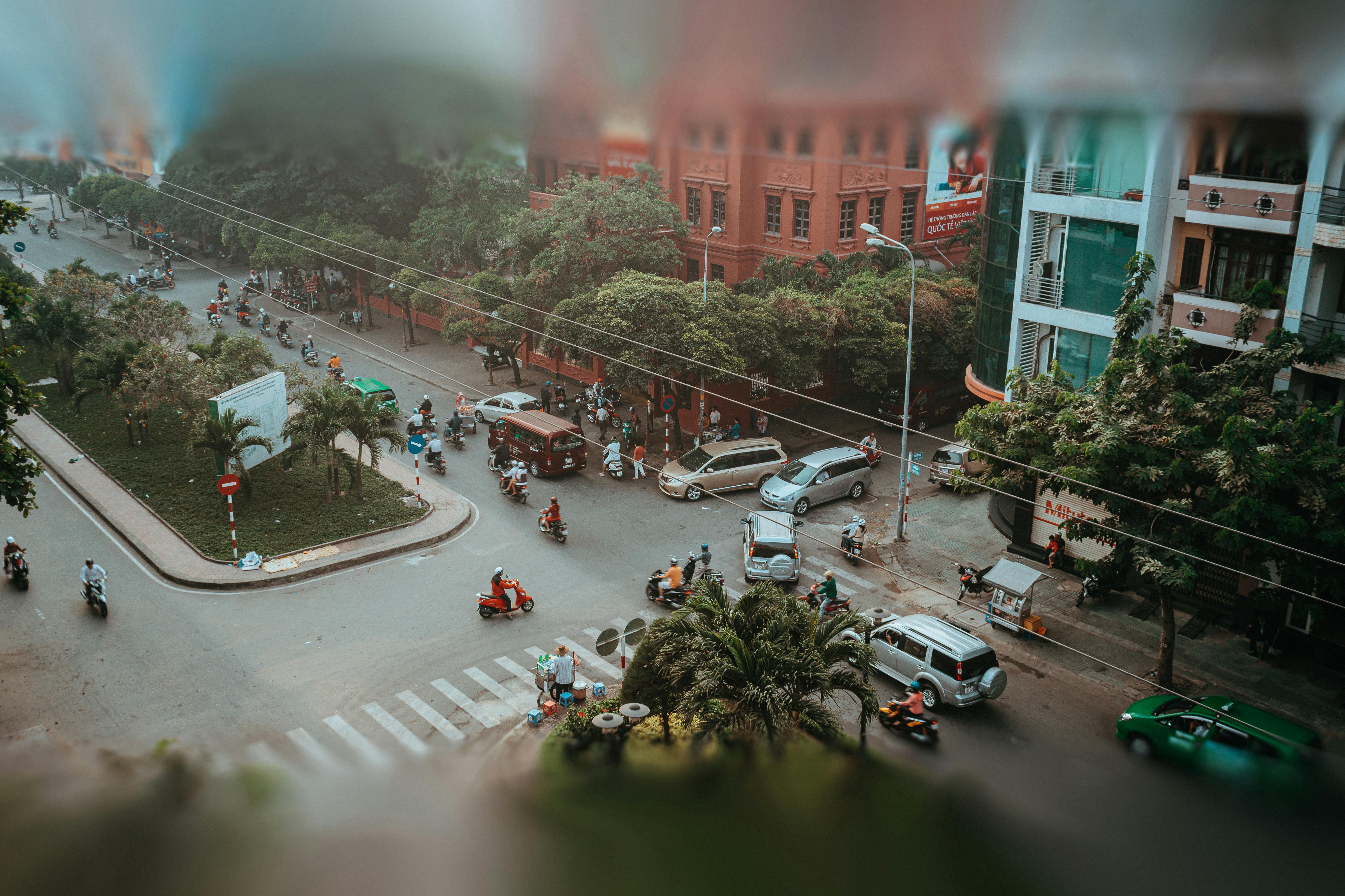 Aerial view of a busy intersection in Ho Chi Minh City, showcasing the urban hustle with motorbikes and cars.