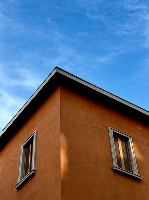 Free A modern building corner with blue sky and clouds in the background. Stock Photo