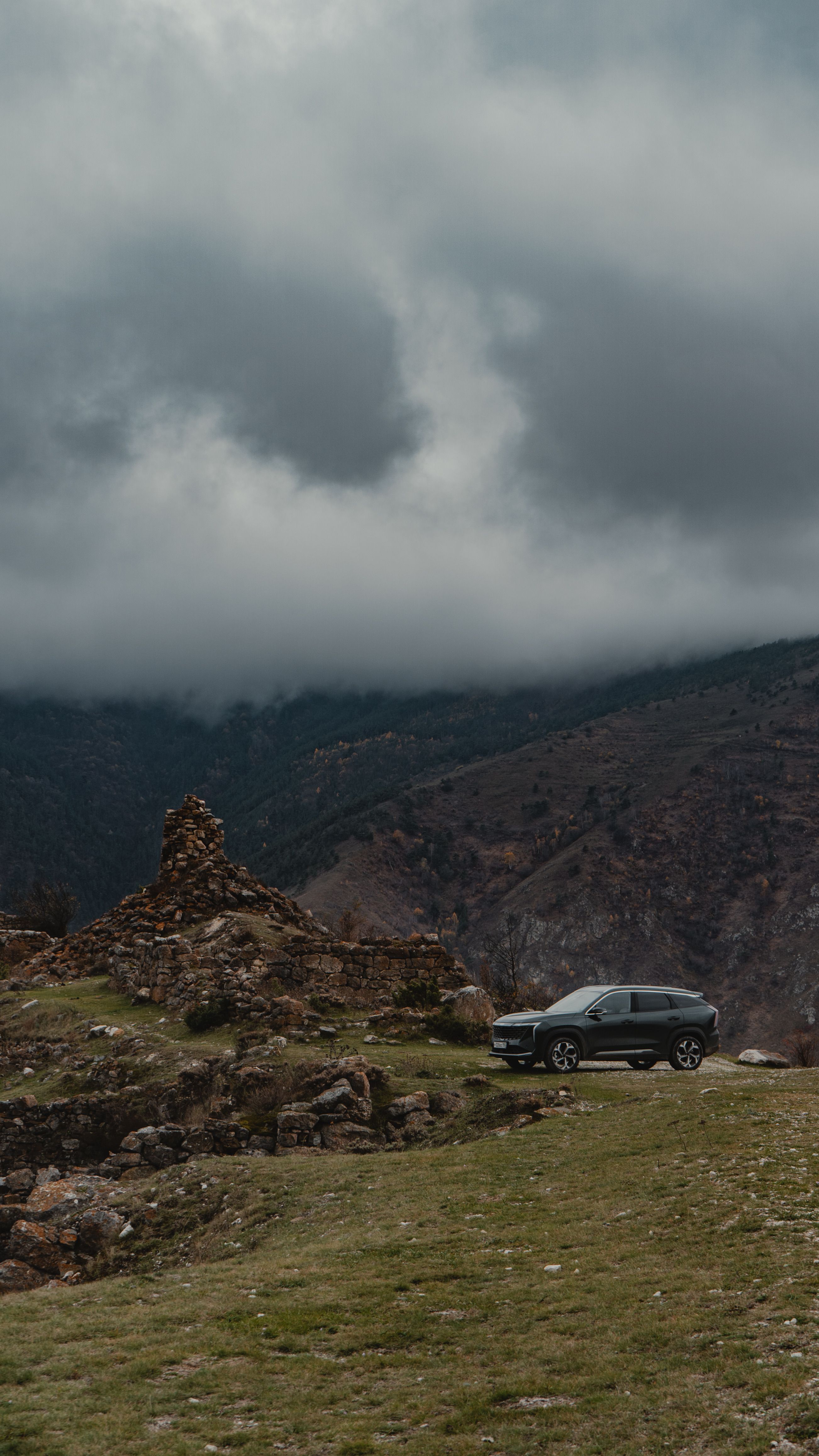 An SUV driving through the dramatic mountain landscape of North Ossetia, Russia.