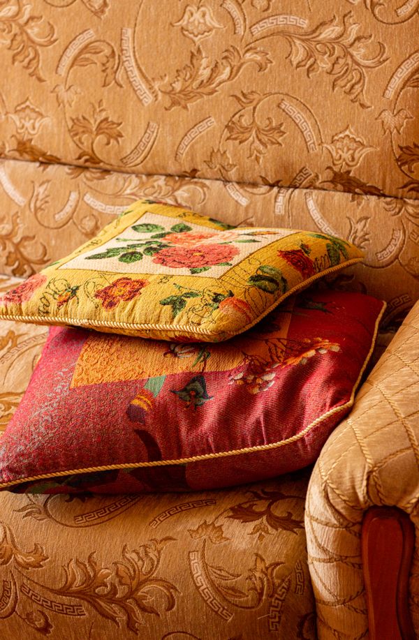 Decorative cushions on a floral patterned sofa — photo by Natalia Sevruk on Pexels