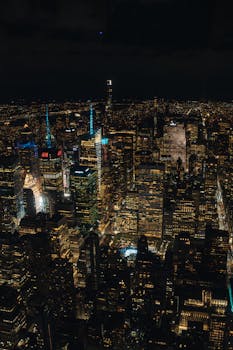 Stunning aerial view of New York City skyline illuminated at night, showcasing iconic skyscrapers.