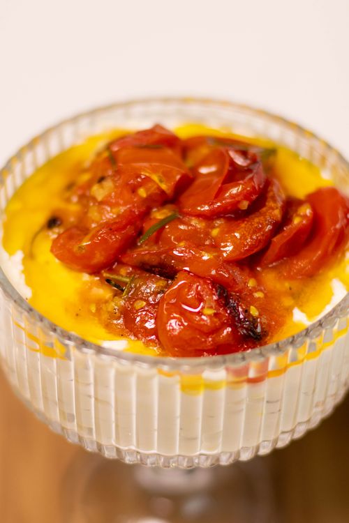 Free A mouthwatering dish featuring cherry tomatoes and burrata cheese, elegantly presented in a glass bowl. Stock Photo