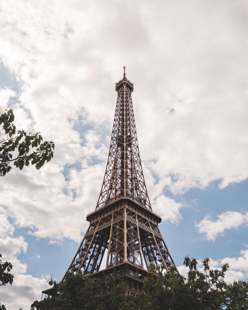 Free Classic view of the Eiffel Tower soaring into a cloudy sky in central Paris, France. Stock Photo