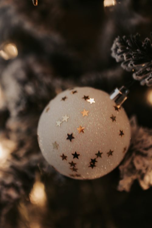 Free A close-up view of a glittery Christmas ornament with star decorations on a tree branch. Stock Photo