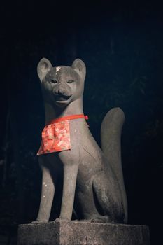 Illuminated fox statue in Kyoto temple at night, highlighting traditional Japanese culture.