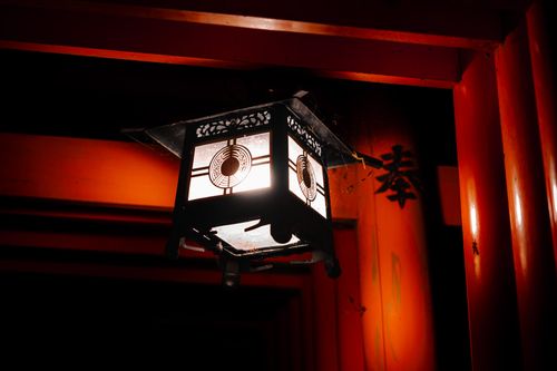 Free A serene Japanese lantern glows warmly at night, showcasing Kyoto architectural beauty. Stock Photo