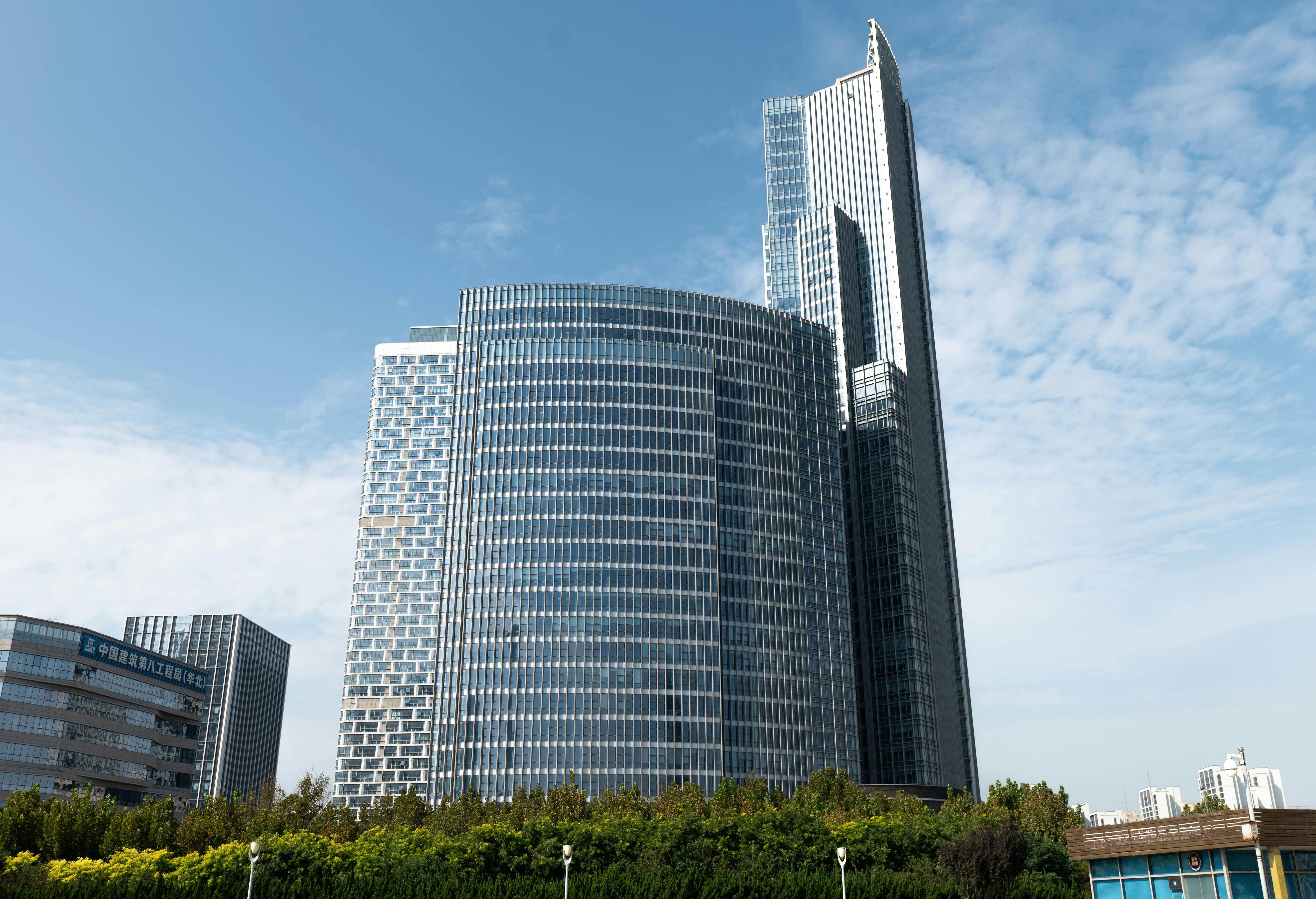 A sleek, modern skyscraper stands tall against a blue sky, showcasing its glass architecture.